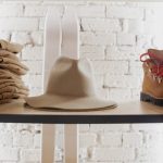 brown cowboy hat on black wooden shelf